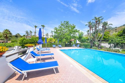 a swimming pool with blue lounge chairs next to a swimming pool at Residence San Domenico in Ischia