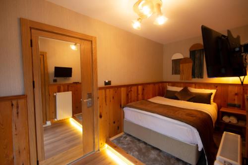 a bedroom with a bed and a television in it at Ayder Koru Hotel in Ayder Yaylasi