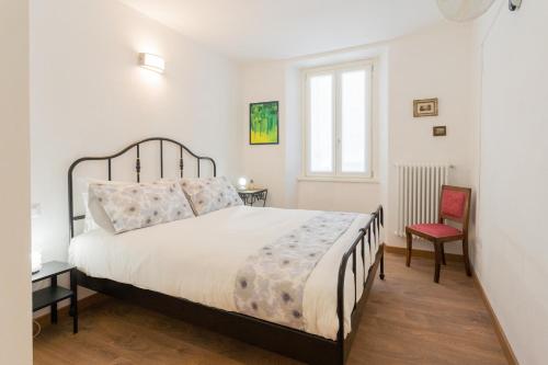 une chambre avec un grand lit et une chaise rouge dans l'établissement Da Pia in Historycal Como City Centre by Rent All Como, à Côme