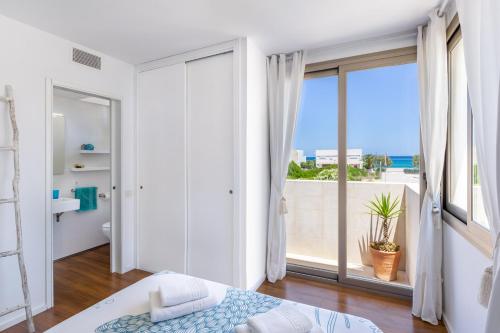 sypialnia z dużym oknem z widokiem na ocean w obiekcie Modern House With Panoramic Sea View In Mallorca w mieście Son Serra de Marina