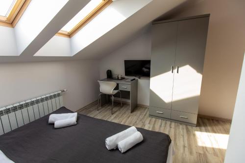 a attic bedroom with a bed and a desk at Nepomucen in Gołąb