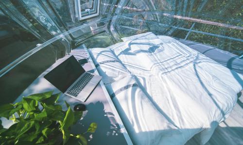 a laptop computer sitting on top of a glass table at Forest Glass inn in Zhangjiajie