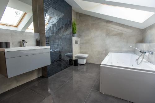 a bathroom with a sink and a tub and a toilet at Nepomucen in Gołąb