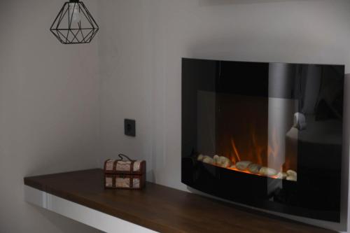 a fireplace in a living room with a fire place at Orion Eco Suites in Karteros