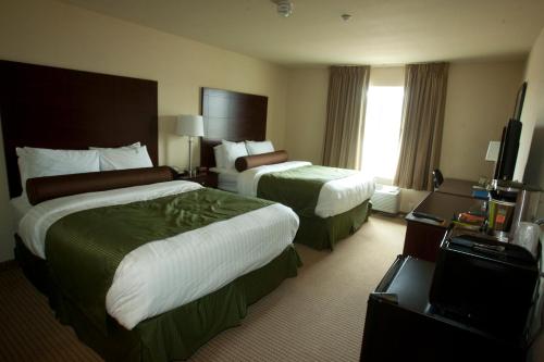a hotel room with two beds and a television at Cobblestone Inn & Suites - Carrington in Carrington
