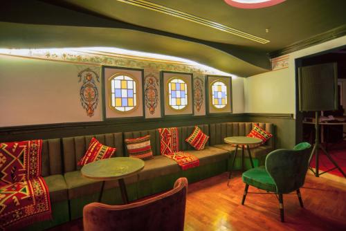 a room with a couch and two tables and windows at Bougainville Bay Apartments in Sarandë