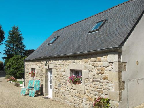 un edificio de piedra con dos sillas azules delante de él en Holiday Home Avel Vor - P, en Saint-Pol-de-Léon