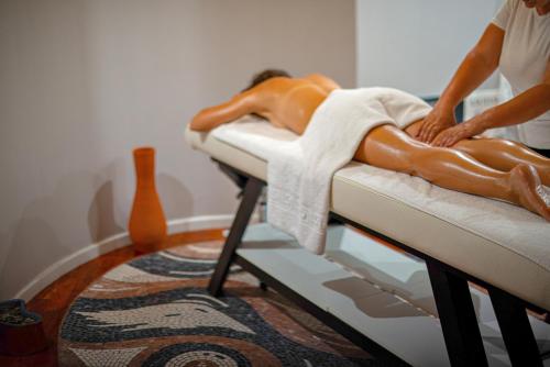 a man laying on a bed in a room at Bougainville Bay Apartments in Sarandë