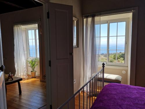 a bedroom with a purple bed and a view of the ocean at vivienda vacacional Benilde in Breña Alta