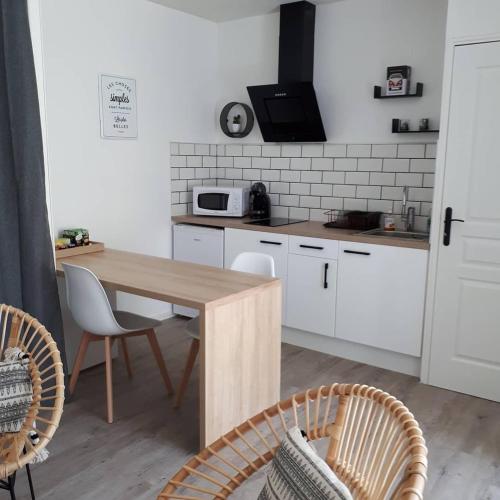 une cuisine avec une table en bois et deux chaises dans l'établissement STUDIO ENTRE PLAGE ET PORT, à Les Sables-dʼOlonne
