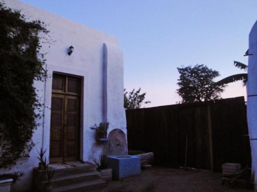 een wit huis met een deur en een hek bij Jardim dos Aloés, Unique B&B - Casa de Charme in Ilha de Moçambique