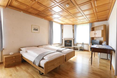 a bedroom with a bed and a desk in it at hotel löwen in Niederuzwil