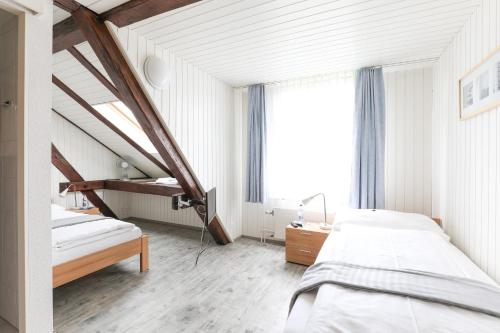 a bedroom with two beds and a window at hotel löwen in Niederuzwil