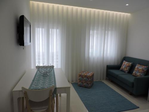 a living room with a table and a couch at Apartamento Atalaia in Nazaré
