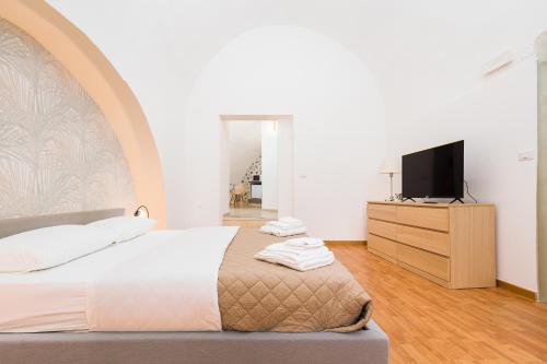 a bedroom with a bed and a flat screen tv at Arco Gentile in Bitonto