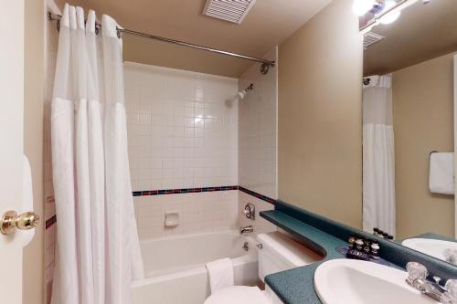 a bathroom with a tub and a toilet and a sink at Marketplace Lodge in Whistler