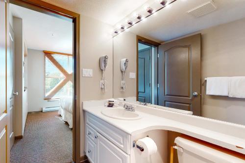ein Badezimmer mit Waschbecken und Spiegel in der Unterkunft Town Plaza Suites in Whistler