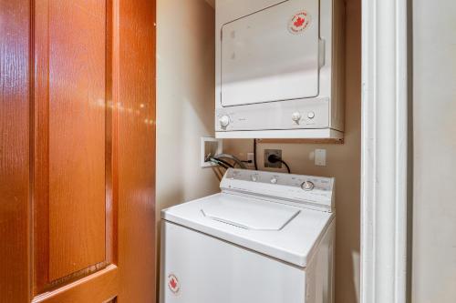 a small kitchen with a white refrigerator and a microwave at Town Plaza Suites in Whistler