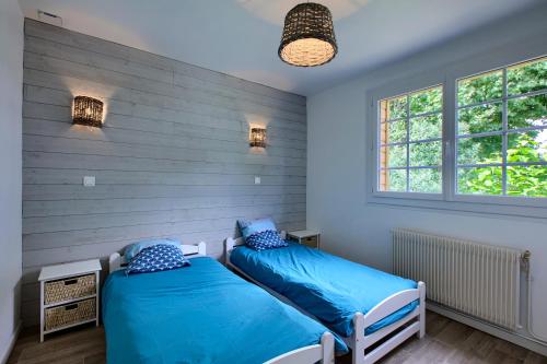 deux lits dans une chambre aux murs bleus dans l'établissement Villa Chez Pepe, à Andernos-les-Bains
