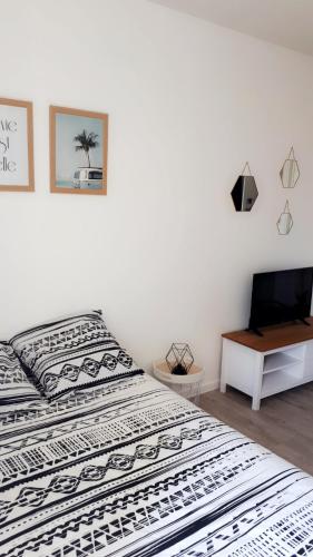 - une chambre avec 2 lits et un bureau avec un ordinateur portable dans l'établissement STUDIO ENTRE PLAGE ET PORT, à Les Sables-dʼOlonne