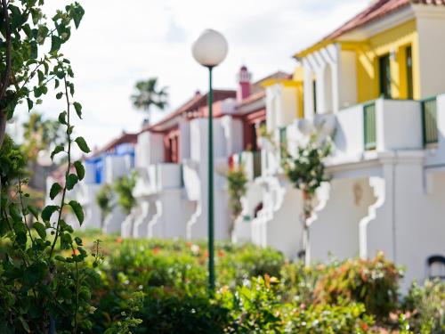 a row of houses with a street light in front at Bungalows Vistaflor in Maspalomas