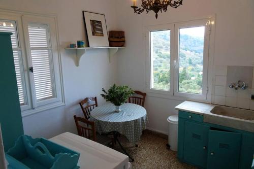 uma casa de banho com uma mesa, um lavatório e 2 janelas em La Maison du Marin em Mesariá