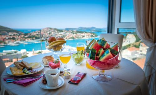 a table with food and drinks on a table with a view at Apartments Dilberovic in Dubrovnik