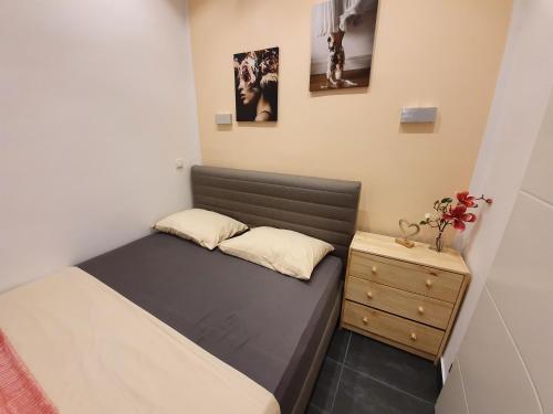 a small bedroom with a bed and a night stand at Design-Apartment mit Klimaanlage & Top-Anbindung an der U1 in Vienna