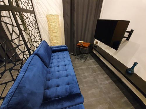 a living room with a blue couch and a tv at Design-Apartment mit Klimaanlage & Top-Anbindung an der U1 in Vienna