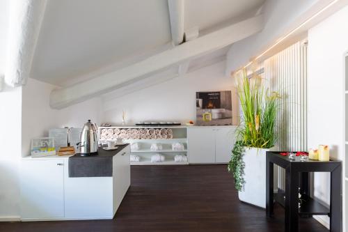 a kitchen with white cabinets and a black counter at Hotel Lago Di Garda in Nago-Torbole