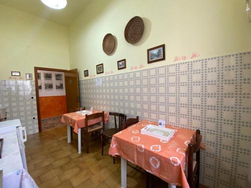 a restaurant with two tables and chairs in a room at Bed and Breakfast da Antonio - Orgosolo in Orgosolo