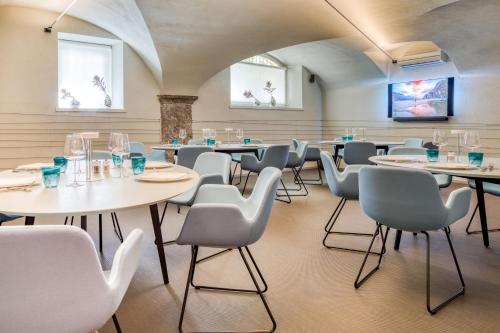 a dining room with white tables and chairs at Hotel Lago Di Garda in Nago-Torbole