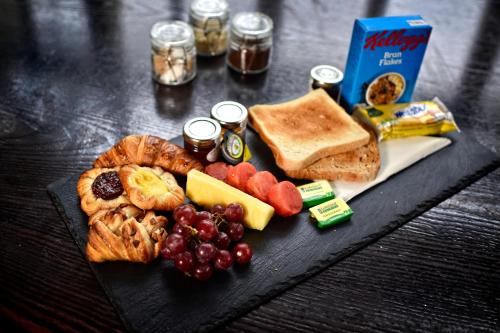 a black plate of food with bread grapes and toast at Red Hall Hotel in Walmersley