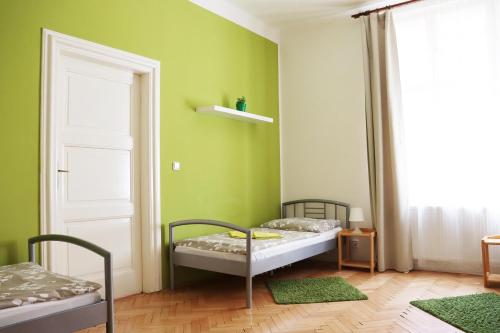 a room with two beds in a room with green walls at Old Town Home Prague in Prague