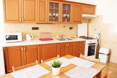 a kitchen with wooden cabinets and a table and a microwave at Old Town Home Prague in Prague