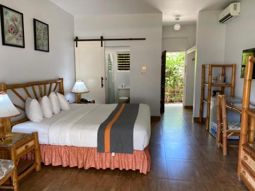 Schlafzimmer mit einem Bett, einem Tisch und Stühlen in der Unterkunft Toby's Resort in Montego Bay