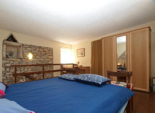 a bedroom with a bed with a blue bedspread at House Peroj 705 in Peroj