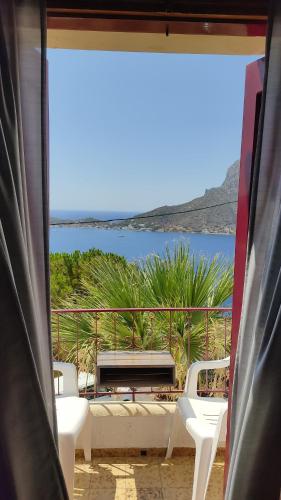 a room with a view of the ocean from a window at Afroditi Hotel in Masouri