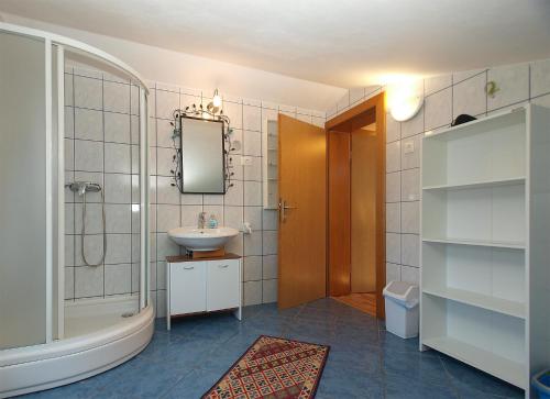 a bathroom with a sink and a mirror and a tub at House Peroj 705 in Peroj