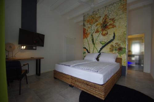 a bedroom with a bed with a painting on the wall at CityMotel Ziegenhain in Schwalmstadt