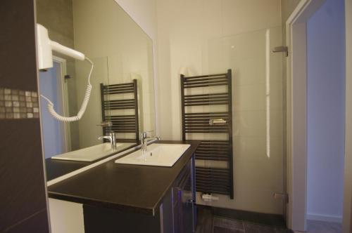 a bathroom with two sinks and a mirror at CityMotel Ziegenhain in Schwalmstadt