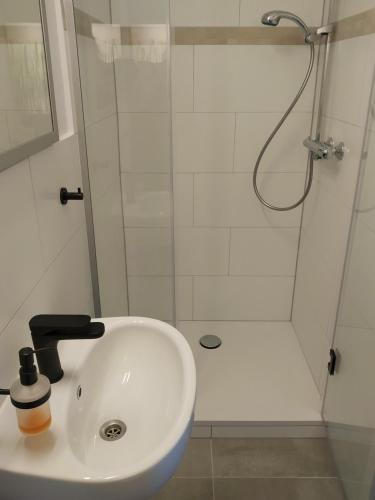 a bathroom with a white sink and a shower at Pension Köthen in Köthen