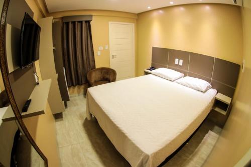 a bedroom with a bed and a flat screen tv at Pôr do Sol Hotel in Santarém