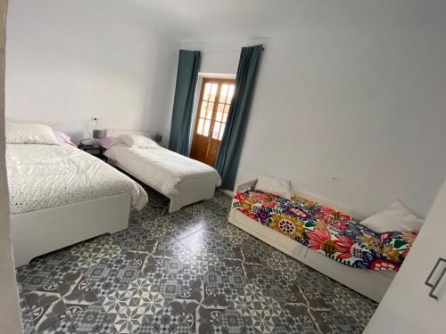 a bedroom with two beds and a window at Casa Las Gardenias in Setenil