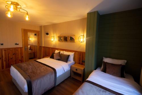 a hotel room with two beds and lights at Ayder Koru Hotel in Ayder Yaylasi