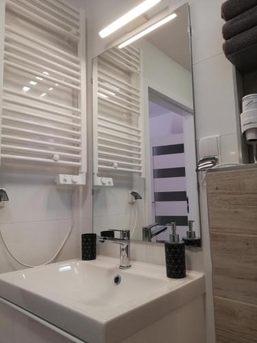 a white bathroom with a sink and a mirror at Domek nad jeziorem 7 in Kamienica Królewska