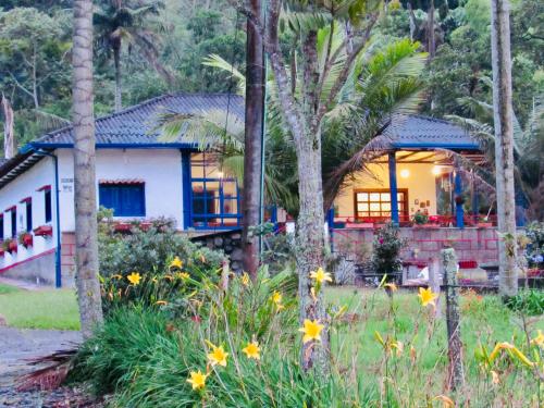 a house in the middle of a garden with flowers at Reserva Guadalajara - Cocora Valley in Salento