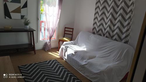 1 dormitorio con cama blanca y ventana en Appartement tout confort au calme avec jacuzzi, en Mouguerre