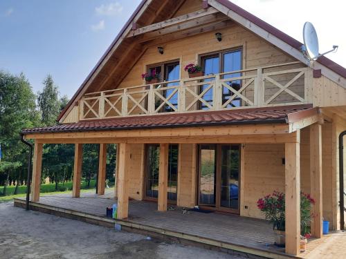 una grande casa in legno con portico e finestre di Willa Kaszubiak a Ostrzyce