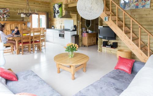 a living room with a table and a kitchen at 6 persoons vakantiehuis met sauna, dichtbij zee in Sint Annaland